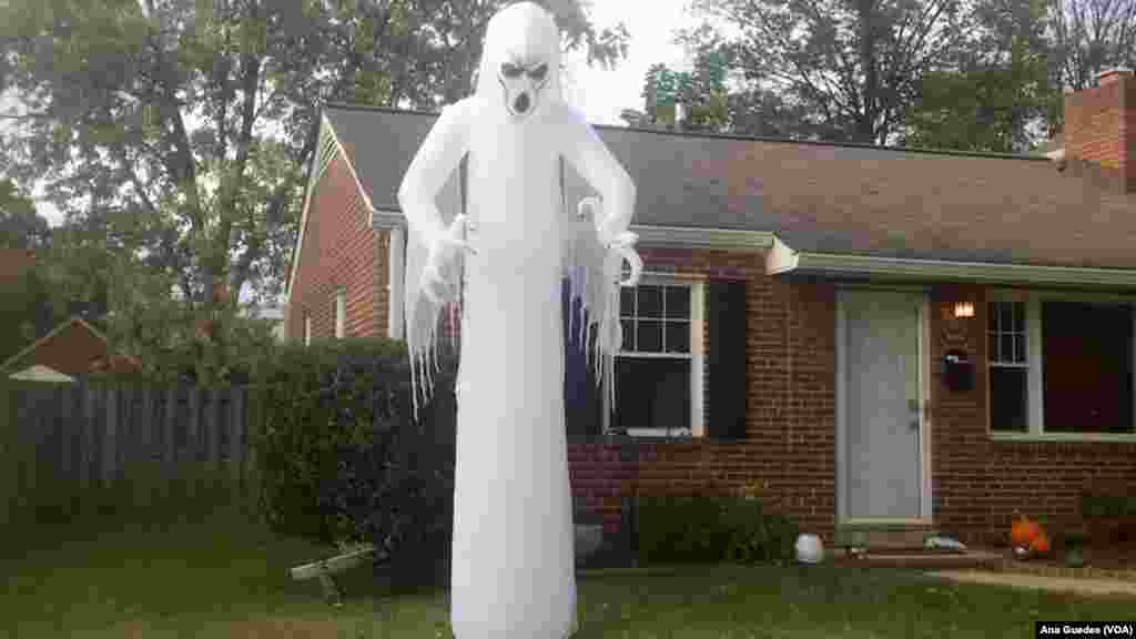 Fantasmas assustadores são colocados em frente às casas nas decorações para o Dia das Bruxas
