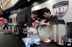 Competitors perform speed tests using dry ice to cool hardware at OC World Record Stage 2018 during the Computex Taipei, one of the world's largest IT expos, in Taipei, Taiwan, June 5, 2018.