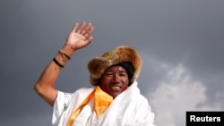 FILE - Kami Rita Sherpa, a Nepali mountaineer, waves toward the media in Kathmandu, Nepal, May 20, 2018.