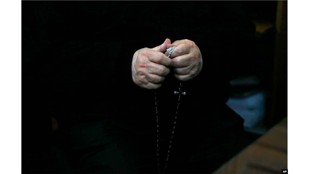 FILE - Rev. Fernando Karadima, Chile’s most infamous pedophile priest, holds a rosary in court before testifying in a case that three of his victims brought against the country’s Catholic Church in Santiago, Chile, Nov. 11, 2015.