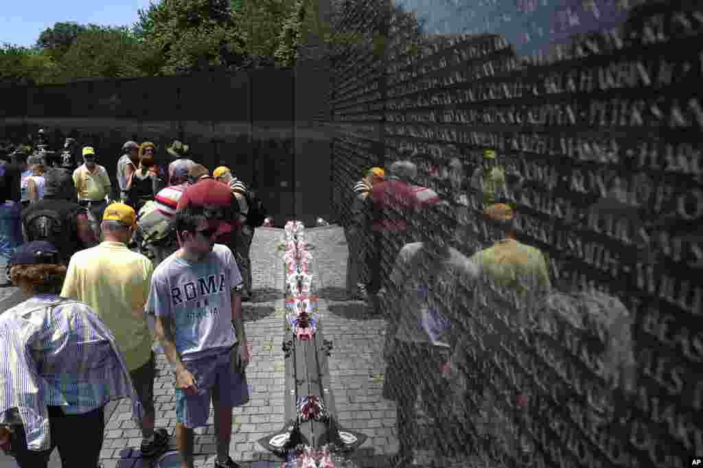 People visit the Vietnam Veterans Memorial, etched with the names of more than 58,000 U.S. servicemen and women who died in the war, on Memorial Day weekend in Washington, May 27, 2012.
