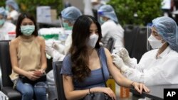 Petugas kesehatan memberikan suntikan vaksin Sinovac COVID-19 kepada karyawan maskapai penerbangan di pusat perbelanjaan Siam Paragon di Bangkok, Thailand, Selasa, 25 Mei 2021. (Foto: AP/Sakchai Lalit)