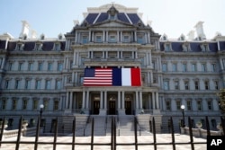 The U.S. and French flags are displayed on the Eisenhower Executive Office Building, April 20, 2018, in Washington.