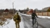 FILE - A Ukrainian serviceman patrols a street near the frontline with Russia-backed separatists in Verkhnotoretske village in Yasynuvata district, Donetsk region, eastern Ukraine, Jan. 22, 2022.