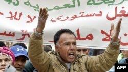 Un manifestant chante des slogans alors qu'il se réunissait avec d'autres sur la place Mohamed Bouazizi dans le centre de la ville de Sidi Bouzid, dans le centre de la Tunisie, le 17 décembre 2020.