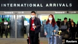 Para penumpang keluar dari Bandara Los Angeles setibanya dari Shanghai, China, di tengah merebaknya kasus positif virus corona di Orange County, Los Angeles, California, 26 Januari 2020.