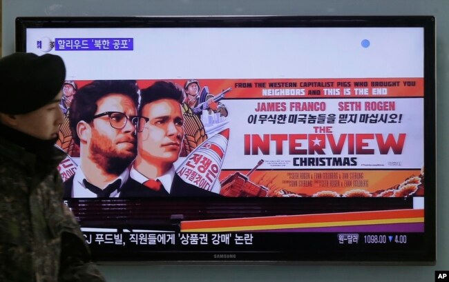FILE - A South Korean army soldier walks near a TV screen showing an advertisement of Sony Picture's "The Interview," at the Seoul Railway Station in Seoul, South Korea, Dec. 22, 2014.