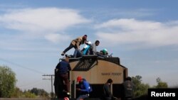 Central American migrants, moving in a caravan through Mexico, travel on a wagon of a freight train after stopping it on the rail line, in Michoacan state, Mexico, April 17, 2018. 