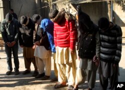 FILE - Pakistani suspects allegedly affiliated with the Islamic State group wait to appear in the anti-terrorist court in Gujranwala, Pakistan, Dec. 29, 2015.