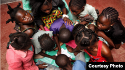 Children gather around a table at SOS Children's Villages Bangui. (Photo by Till Müllenmeister)