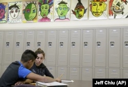 In this April 19, 2016 photo, Laurie Millan, a para-professional and tutor, works with a student during an after school tutoring session at San Francisco International High School, in San Francisco. (AP Photo/Jeff Chiu)