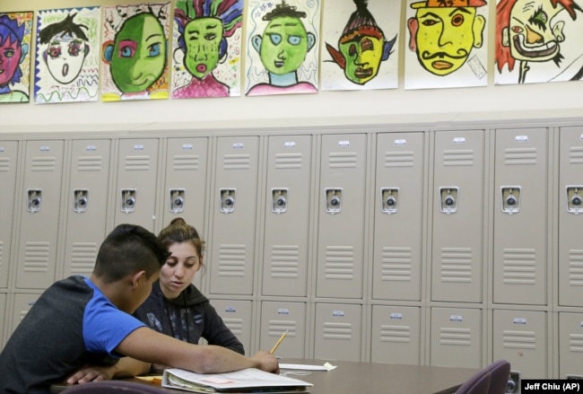 In this April 19, 2016 photo, Laurie Millan, a para-professional and tutor, works with a student during an after school tutoring session at San Francisco International High School, in San Francisco. (AP Photo/Jeff Chiu)