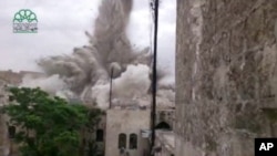 This image made from amateur video posted by Shaam News Network (SNN), an anti-Bashar Assad activist group, shows an explosion that destroyed the Carlton Hotel in Aleppo, Syria, May 8, 2014.