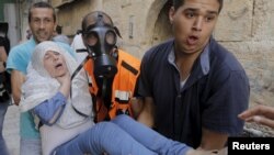 A Palestinian woman affected by tear gas is evacuated by medics during clashes between stone-throwing Palestinians and Israeli police on the compound known to Muslims as Noble Sanctuary and to Jews as Temple Mount in Jerusalem's Old City September 15, 2015.