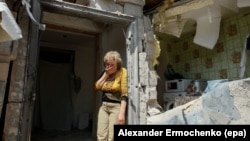 FILE - A local woman reacts next to her destroyed home after shelling in pro-Russian rebel controlled Staromykhaylivka village near Donetsk, Ukraine, May 24, 2016.