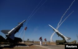 People watch S-300 air defense missile systems launching missiles during the Keys to the Sky competition.