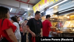 A customer leaves after collecting a bag of Bak Kwa, a traditional Southern Chinese pork jerky popular among Singaporean Chinese for Lunar New Year celebrations. Photo taken on January 18, 2020. REUTERS/Loriene Perera