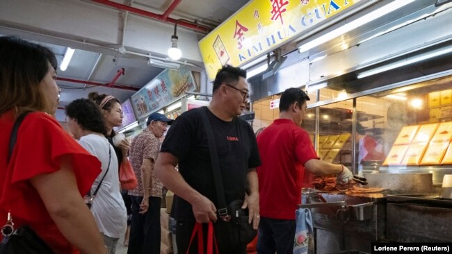 A customer leaves after collecting a bag of Bak Kwa, a traditional Southern Chinese pork jerky popular among Singaporean Chinese for Lunar New Year celebrations. Photo taken on January 18, 2020. REUTERS/Loriene Perera