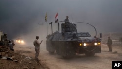 Kendaraan lapis baja Polisi Federal Irak melewati pos pemeriksaan di Qayyara, 50 kilometer dari selatan Mosul, Irak (26/10). (AP/Marko Drobnjakovic)