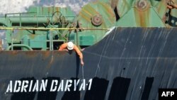 Seorang awak kapal memeriksa nama kapal tanker yang diganti menjadi Adrian Darya, sebelumnya bernama Grace 1, di perairan Gibraltar hari Minggu (18/8). 