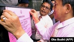 Jaksa penuntut, Suriansyah (kanan), memposting pengumuman penyitaan di menara perkantoran Granadi di pusat kota Jakarta pada 21 Juli 2000. (Foto: AFP/Oka Budhi)