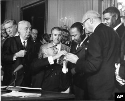 FILE - The Rev. Martin Luther King, third from right, was among national figures present on July 2, 1964, as President Lyndon B. Johnson signed the Civil Rights Bill. (AP Photo)