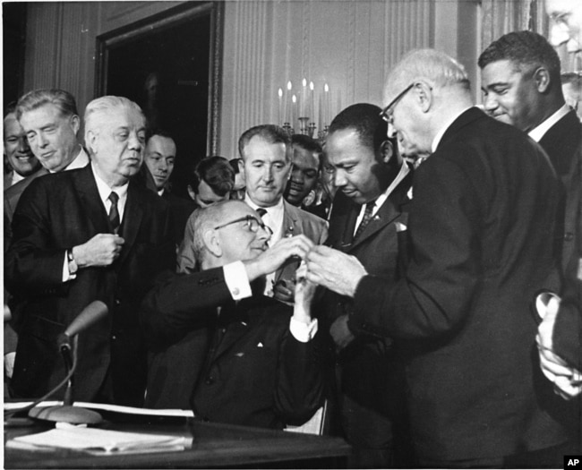 FILE - The Rev. Martin Luther King, third from right, was among national figures present on July 2, 1964, as President Lyndon B. Johnson signed the Civil Rights Bill. (AP Photo)