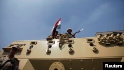 Members of the military hold their weapons atop a vehicle, on a road leading to the Raba El-Adwyia mosque square where supporters of Egypt's deposed President Mohamed Morsi are camping, in Cairo, July 4, 2013.