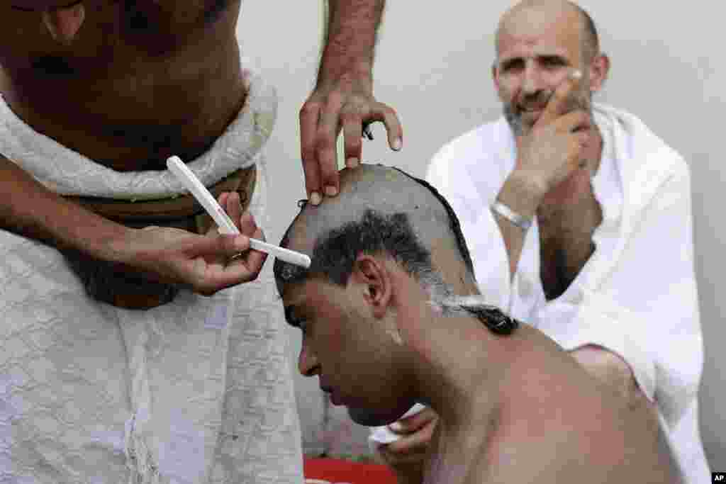 A Muslim pilgrim has his head ritually shaved after he cast stones at a pillar in Mina near the Saudi holy city of Mecca, October 26, 2012.