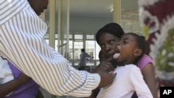 A doctor examines a child suffering from typhoid at a local infectious disease hospital in Harare, Zimbabwe, November15, 2011. 