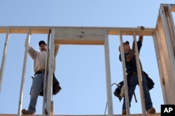 FILE - Construction workers David Rager, right, and Shawn White frame the upper floor of a home being built in Orlando, Florida, Feb. 13, 2015.