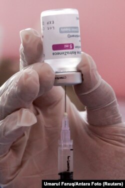 Seorang petugas kesehatan menyiapkan satu dosis COVID-19 buatan AstraZeneca di puskesmas di Sidoarjo, dekat Surabaya, Jawa Timur, 22 Maret 2021. (Foto: Umarul Faruq/Antara Foto via Reuters)