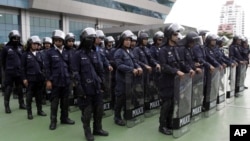 Thai riot policemen stand guard outside the Constitution Court during a ruling Friday, July 13, 2012 in Bangkok, Thailand.