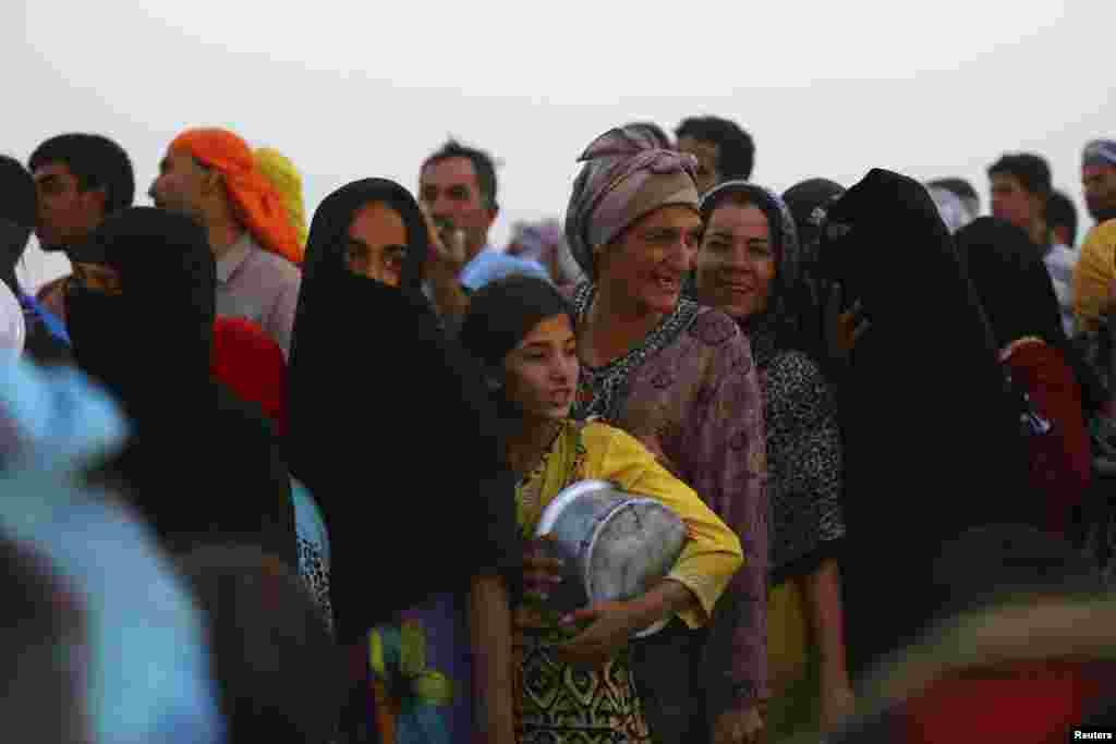 Iraqi refugees who fled from the violence in Mosul line up to receive free food during the holy fasting month of Ramadan, inside the Khazer refugee camp on the outskirts of Irbil, in Iraq's Kurdistan region, June 29, 2014.