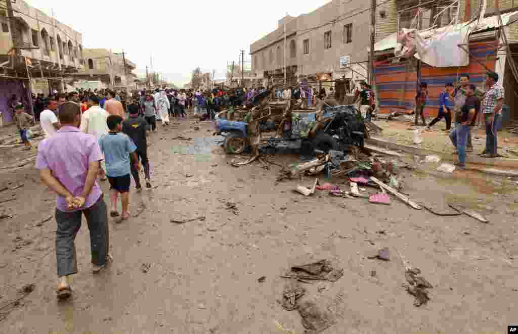 People look at the scene of a car bomb attack in a predominantly Shi&#39;ite area of eastern Baghdad, May 20, 2013.