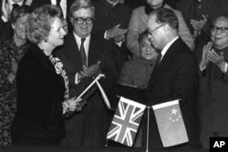 英国首相玛格丽特·撒切尔和中国总理赵紫阳1984年12月19日在北京交换香港移交协议。邓小平在场。