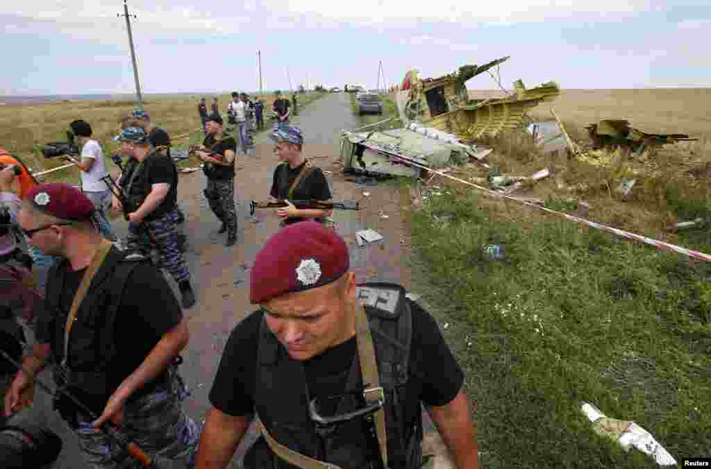 Armed pro-Russian separatists stand guard at a crash site of Malaysia Airlines Flight MH17, near the village of Hrabove, Donetsk region, eastern Ukraine, July 20, 2014.