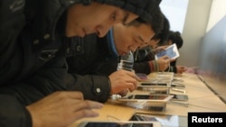 Para pelanggan mencoba iPad di sebuah toko di Shanghai. (Foto: Dok)
