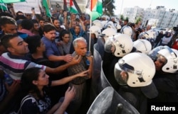 Protesters argue with Palestinian riot police during a protest against security coordination between Palestinian authority and Israel, in the West Bank city of Ramallah, June 23, 2014.