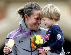 FILE - Gold medalist Kristin Armstrong of the United States celebrates with her son, Lucas, after the women's individual time trial event at the 2012 Summer Olympics in London, Aug. 1, 2012.