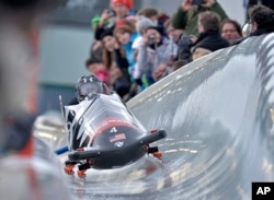 FILE - Steven Holcomb, front, and Steven Langton from the U.S. speed down the run during the two-man bobsled World Cup in Winterberg, Germany, Jan. 3, 2014.