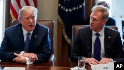 FILE - In this April 9, 2018, photo, Deputy Secretary of Defense Patrick Shanahan, right, listen as President Donald Trump speaks during a cabinet meeting at the White House, in Washington.