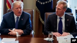 FILE - In this April 9, 2018 photo, Deputy Secretary of Defense Patrick Shanahan, right, listen as President Donald Trump speaks during a cabinet meeting at the White House, in Washington.