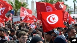 Protestors gather during an anti-extremism march, in Tunis, Sunday, March 29, 2015. Tens of thousands of Tunisians from across the political spectrum marched through the capital Sunday to denounce extremist violence after a deadly museum attack on foreign