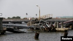FILE - An oil discharge facility which was used to transfer imported oil from ships at the Atlas Cove depot, is seen damaged after militants from the Niger delta bombed it, in Lagos, Nigeria, Nov. 10, 2016.