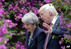 El presidente Donald Trump, y la primera ministra británica Theresa May, conversan durante la Cumbre del G7 en Taormina, Italia. Mayo 26, 2017.