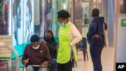 People wait to get vaccinated at a shopping mall, in Johannesburg, South Africa, Nov. 26, 2021. 