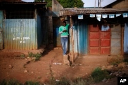 FILE - A man checks his phone in Kibera, Africa's largest slum, in Nairobi, Kenya, March 6, 2013.