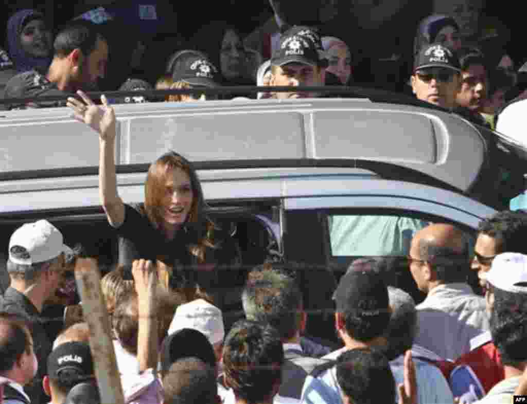 Angelina Jolie, Hollywood actress and goodwill ambassador for the U.N. High Commissioner for Refugees, UNHCR, waves as she exits a van surrounded by Syrian refugees at the Altinozu refugee camp, Turkey, near the Syrian border, Friday, June 17, 2011. U.N. 