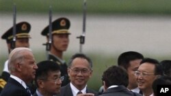 美國副總統拜登(左)抵達北京首都國際機場﹐美國駐中國大使駱家輝(左二)和中國外交部長楊潔篪(右)在機場迎接。